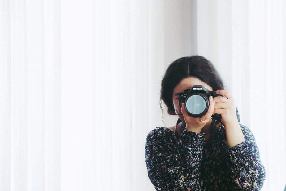 woman-holding-camera-white-background