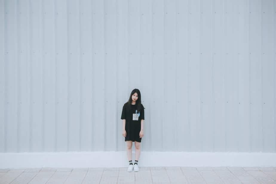 young-woman-wearing-black-standing-alone-white-wall