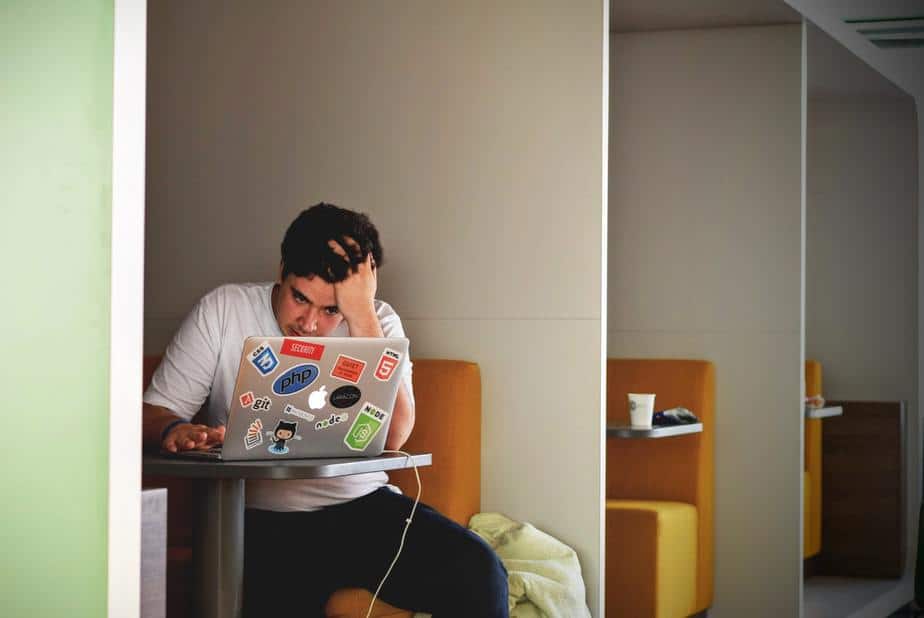 young-man-sitting-with-computer-in-booth